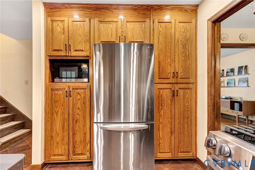 11410 Driscoll Road, Chester, VA 23831 Floor-to-ceiling oak cabinetry, stainless steel refrigerator, built-in microwave, and tile flooring