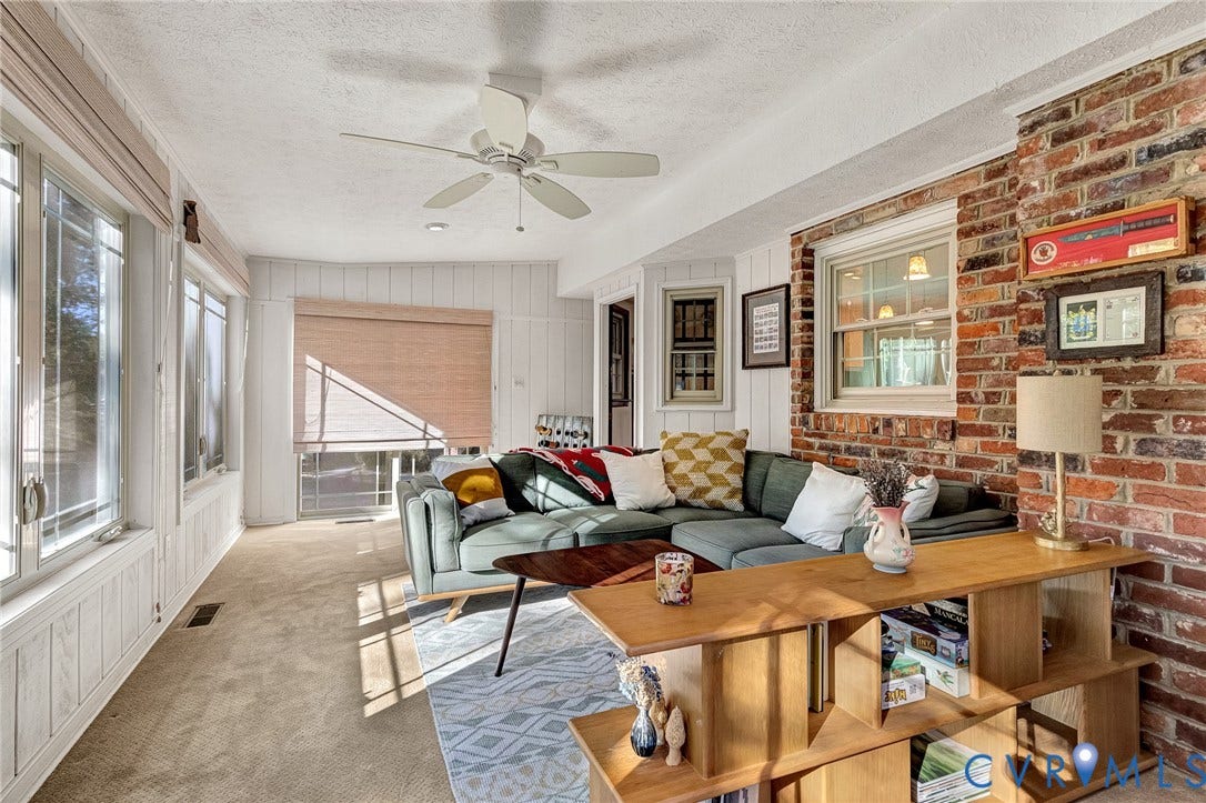 11410 Driscoll Road, Chester, VA 23831 Sunroom featuring floor-to-ceiling windows, exposed brick accent wall, white vertical paneling, and a ceiling-mounted fan