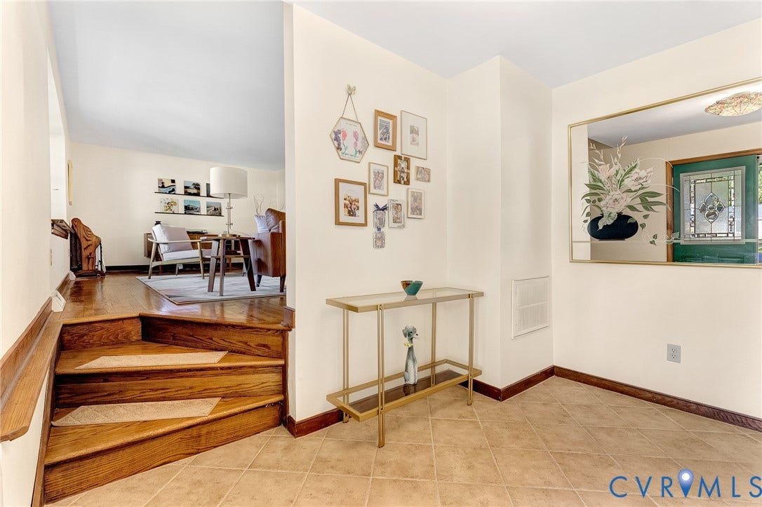 11410 Driscoll Road, Chester, VA 23831 Entryway featuring ceramic tile flooring, a built-in recessed mirror, a curved wooden staircase with integrated steps, and a decorative front door with leaded glass inlay