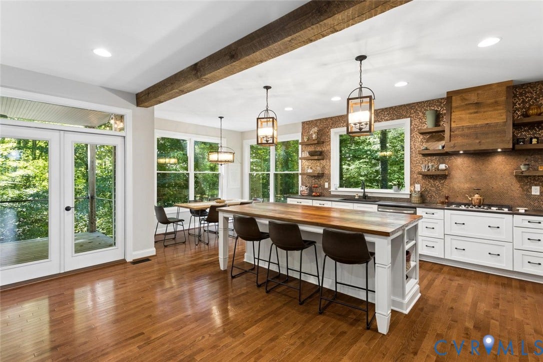 9013 Old Holly Road, Southhampton, Richmond, VA 23235 Hardwood flooring throughout, white cabinetry with dark countertops, a wooden kitchen island with seating, a textured backsplash, and a wooden range hood