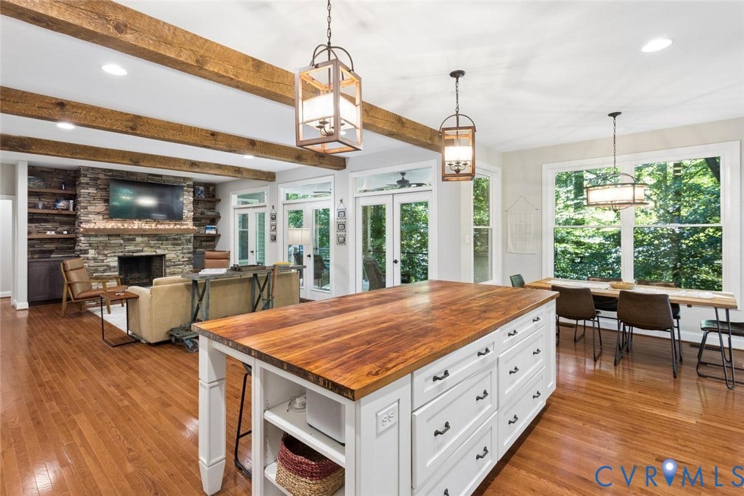 9013 Old Holly Road, Southhampton, Richmond, VA 23235 Hardwood flooring throughout, a large kitchen island with a wood-finish countertop, white cabinetry with dark hardware, and exposed wood beams