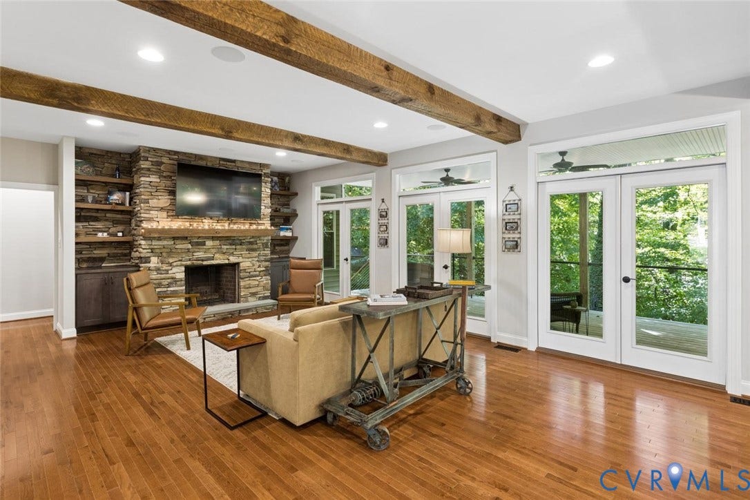 9013 Old Holly Road, Southhampton, Richmond, VA 23235 Expansive living space featuring hardwood flooring, exposed wood beams, a stone-clad fireplace, built-in shelving, and multiple French doors