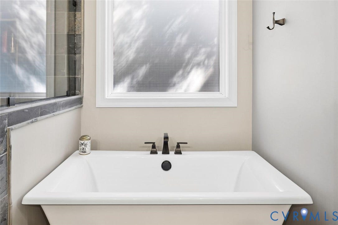 9013 Old Holly Road, Southhampton, Richmond, VA 23235 White soaking tub with dark bronze fixtures, frosted window, and adjacent tiled shower