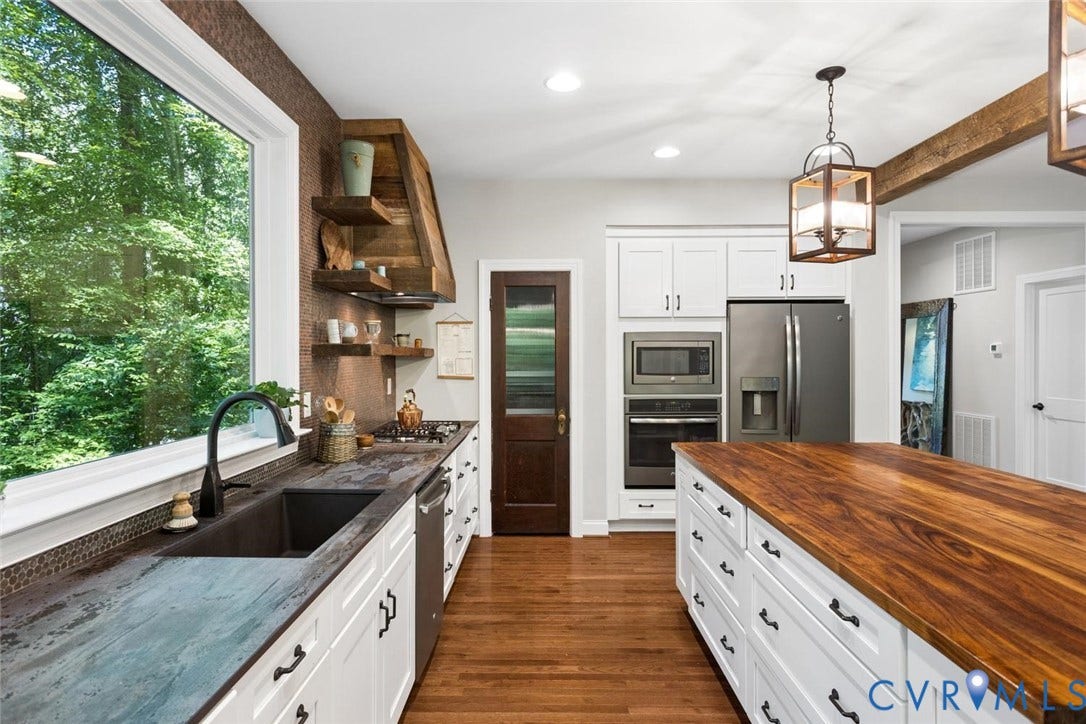 9013 Old Holly Road, Southhampton, Richmond, VA 23235 White cabinetry, wood-finish flooring, stainless steel appliances, large kitchen island with wood-finish countertop, and decorative ceiling beams