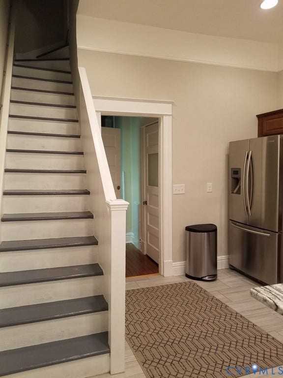 Staircase with painted treads and risers, stainless steel refrigerator, recessed lighting, and tile flooring