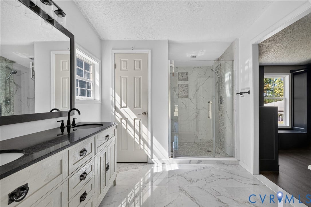 8211 Brills Road, Dinwiddie, VA 23872 Dual vanity with dark countertop, large framed mirror, and matte black fixtures