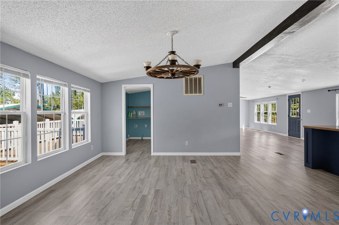8211 Brills Road, Dinwiddie, VA 23872 Spacious interior featuring wood-finish flooring, a decorative chandelier, and a bright, light-filled interior