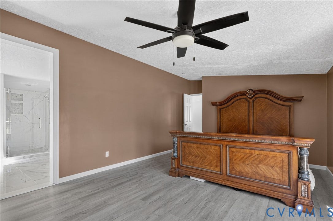 8211 Brills Road, Dinwiddie, VA 23872 Gray wood-finish flooring, ceiling fan, and a walk-in shower with tile surround