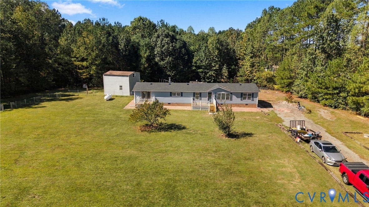 8211 Brills Road, Dinwiddie, VA 23872 Expansive green space, outbuilding, gravel driveway, mature trees, and a light blue exterior