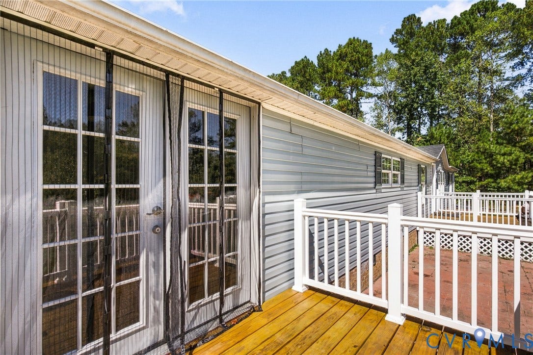 8211 Brills Road, Dinwiddie, VA 23872 Wood-finish deck with white railings, light-colored siding, and white-framed double doors