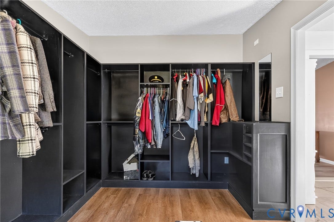 8211 Brills Road, Dinwiddie, VA 23872 Built-in closet system with varied storage configurations, wood-finish flooring, and a wall-mounted mirror
