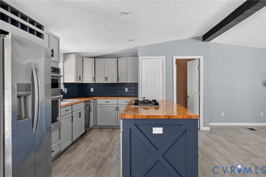 8211 Brills Road, Dinwiddie, VA 23872 Modern kitchen with gray cabinetry, stainless steel appliances, a dark subway tile backsplash, and wood-finish countertops