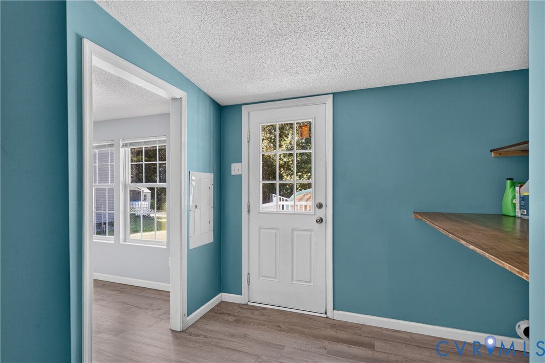 8211 Brills Road, Dinwiddie, VA 23872 Wood-finish flooring, built-in shelving, white paneled door with glass inserts, white framed windows, and a neutral ceiling finish