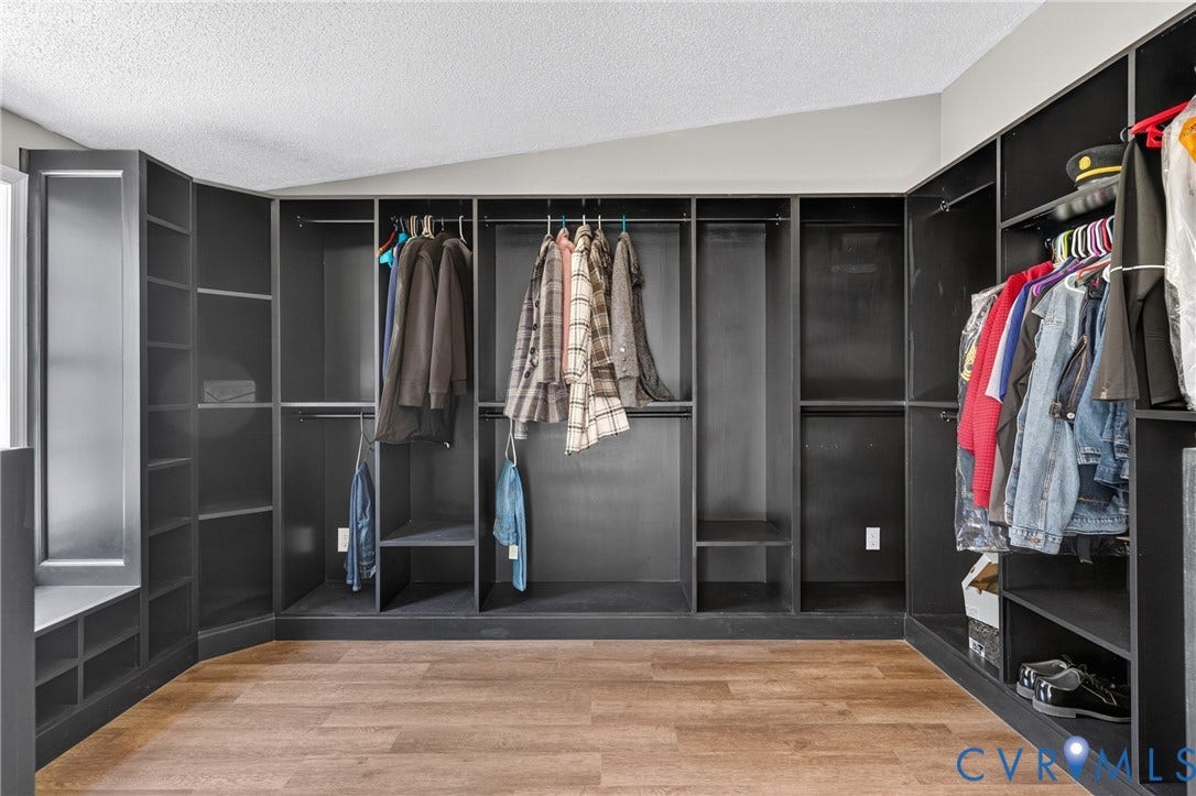8211 Brills Road, Dinwiddie, VA 23872 Custom built-in closet system with varied shelving, multiple hanging rods, and wood-finish flooring