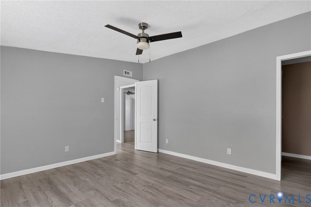 8211 Brills Road, Dinwiddie, VA 23872 Spacious room featuring wood-finish flooring, painted walls, and a ceiling fan with integrated lighting