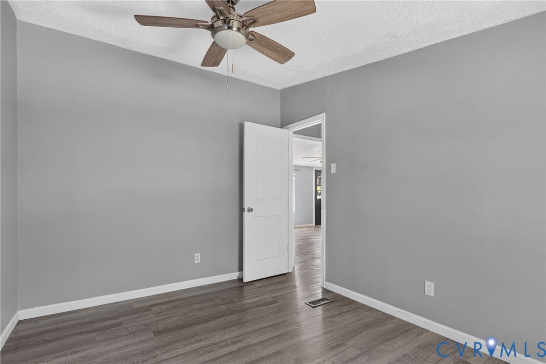 8211 Brills Road, Dinwiddie, VA 23872 Wood-finish flooring, neutral gray wall tones, ceiling fan, and white trim