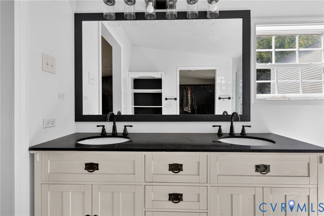 8211 Brills Road, Dinwiddie, VA 23872 Dual vanity with a dark countertop, white oval undermount sinks, and matte black fixtures