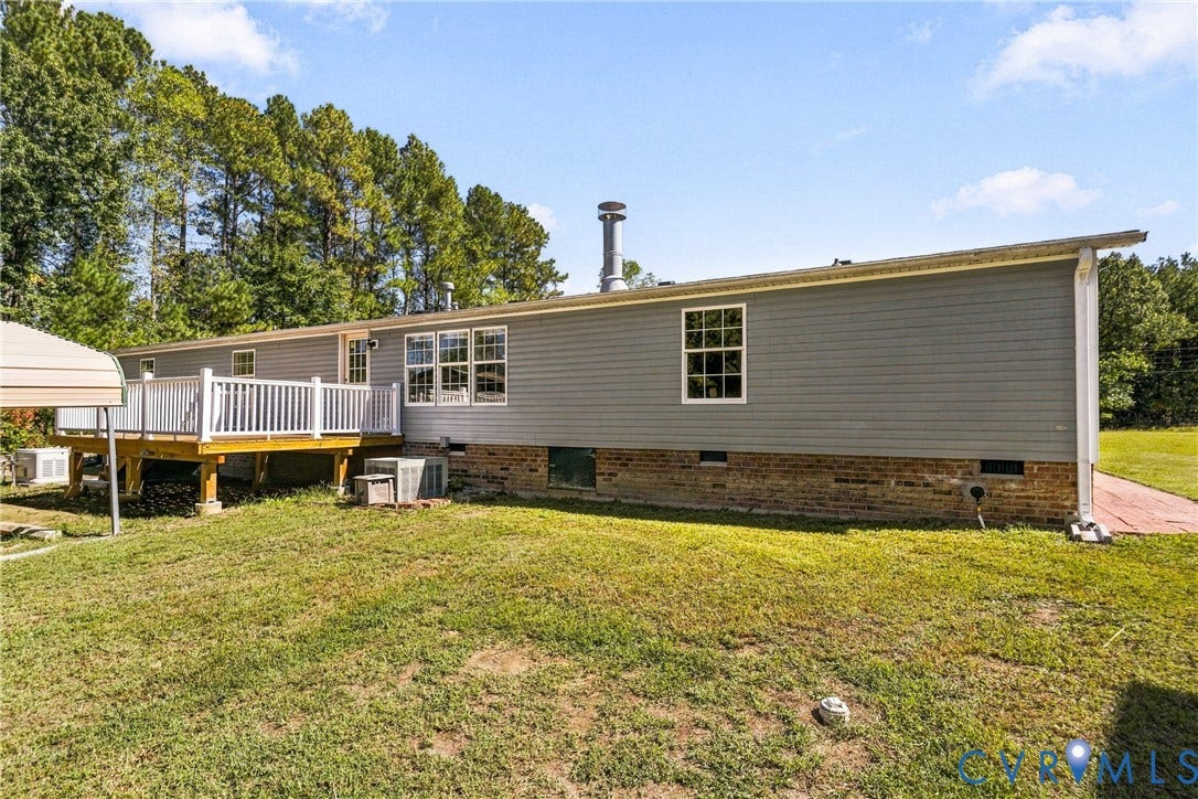 8211 Brills Road, Dinwiddie, VA 23872 Gray siding exterior with a white deck featuring white railings, brick foundation, and multiple windows