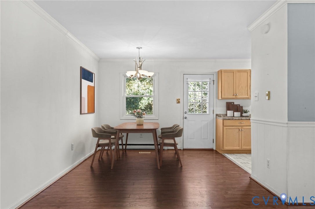 Crown molding and wood-finish flooring complement the bright white walls. Photo digitally staged.