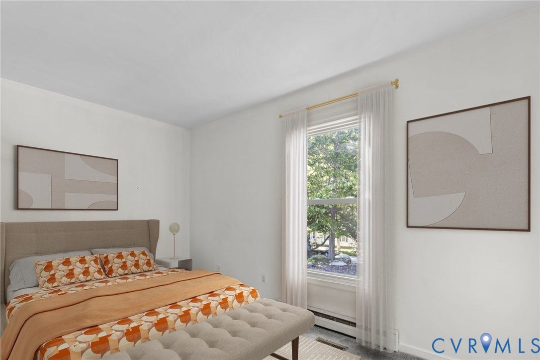 Bright bedroom with a window, white walls, and dark gray carpeting