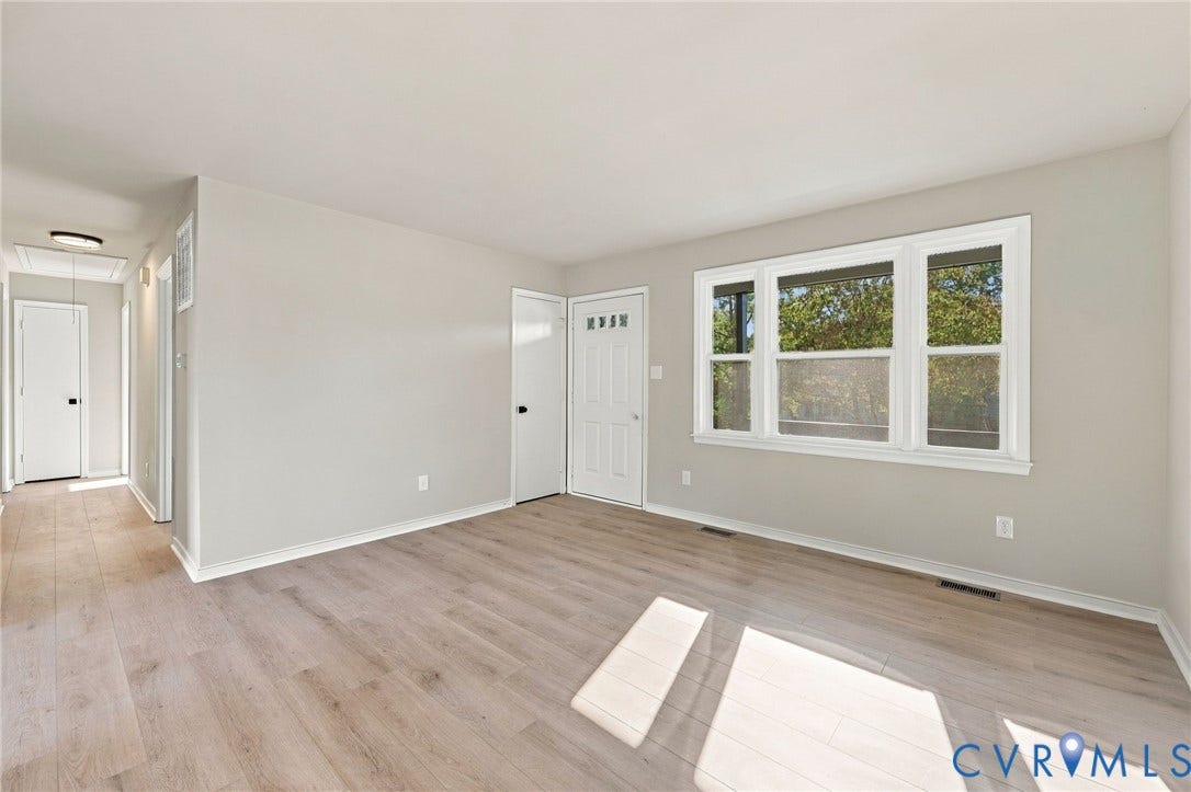 5113 Olympic Lane, North Dinwiddie, VA 23803 Light wood-finish flooring, neutral wall paint, white trim, and a multi-pane window