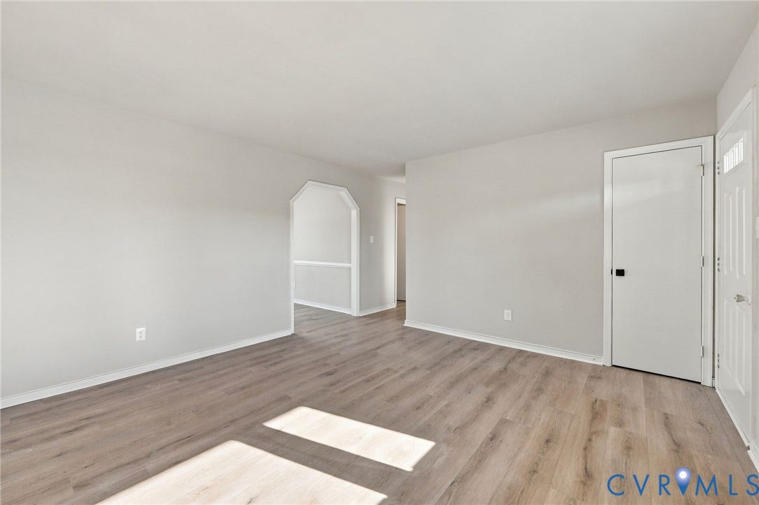 5113 Olympic Lane, North Dinwiddie, VA 23803 Neutral wall paint, wood-finish flooring, white trim throughout, and an arched doorway
