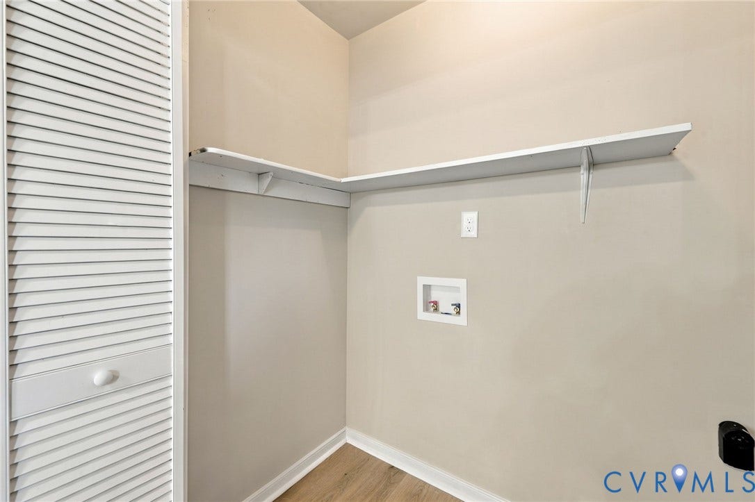 5113 Olympic Lane, North Dinwiddie, VA 23803 Recessed laundry area featuring built-in shelving, wood-finish flooring, and a louvered bi-fold door