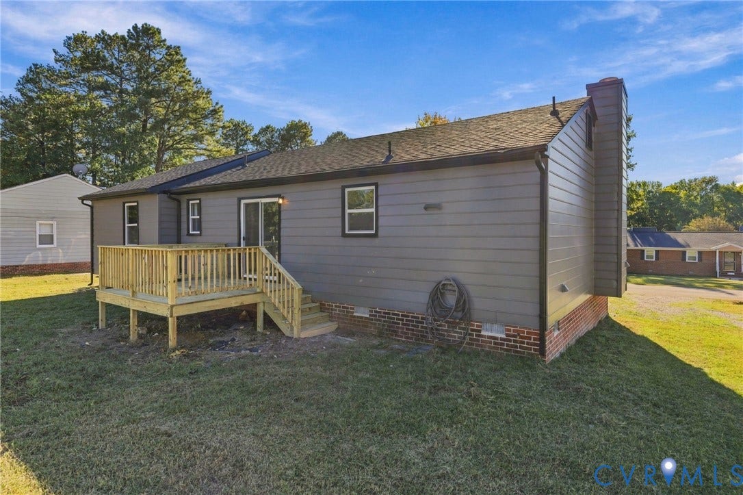 5113 Olympic Lane, North Dinwiddie, VA 23803 Rear exterior featuring a wood deck, sliding glass door, brick foundation, and a shingled roof