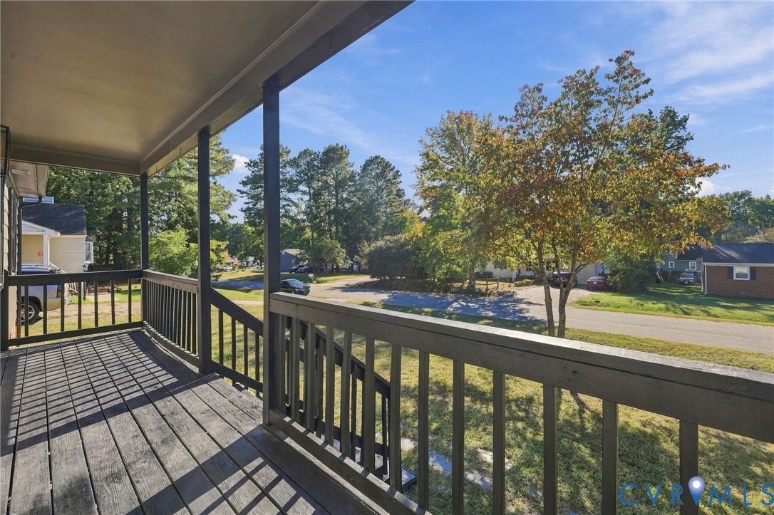5113 Olympic Lane, North Dinwiddie, VA 23803 Spacious covered deck with composite decking and black aluminum railings overlooking the tree-lined neighborhood