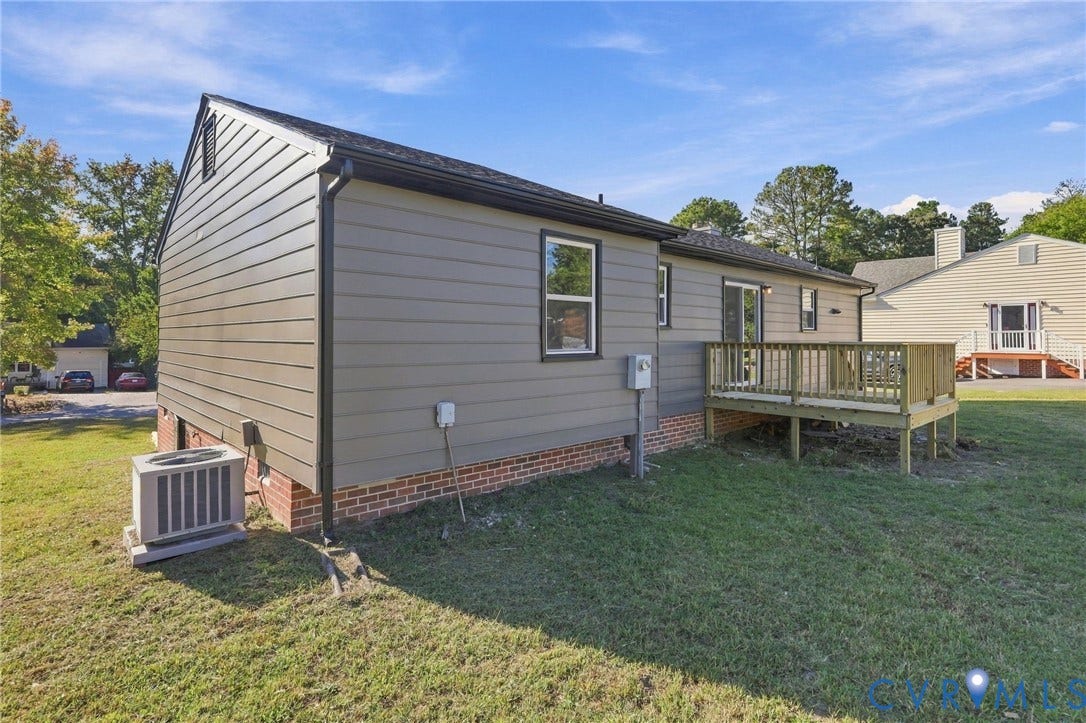 5113 Olympic Lane, North Dinwiddie, VA 23803 Rear exterior with a wooden deck, sliding glass doors, and durable siding over a brick foundation