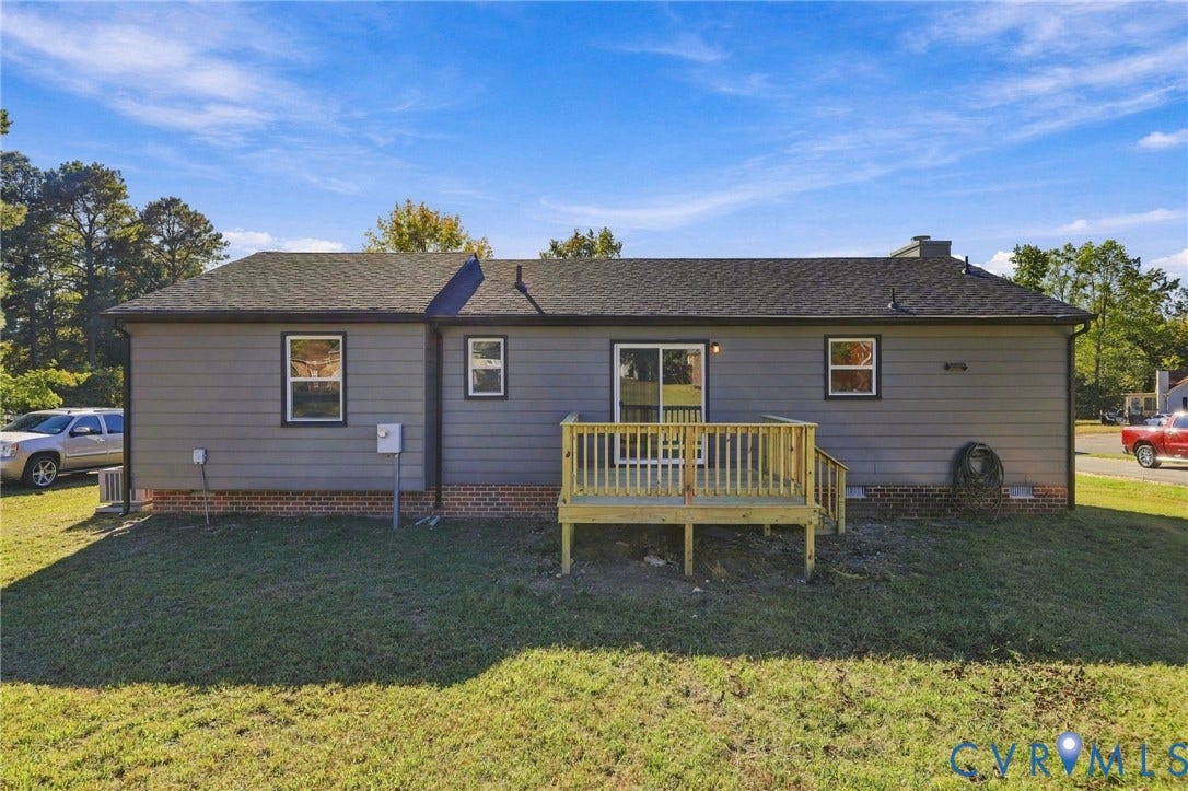 5113 Olympic Lane, North Dinwiddie, VA 23803 Rear exterior with gray siding, a full-height wood deck, sliding glass door, and dark-framed windows