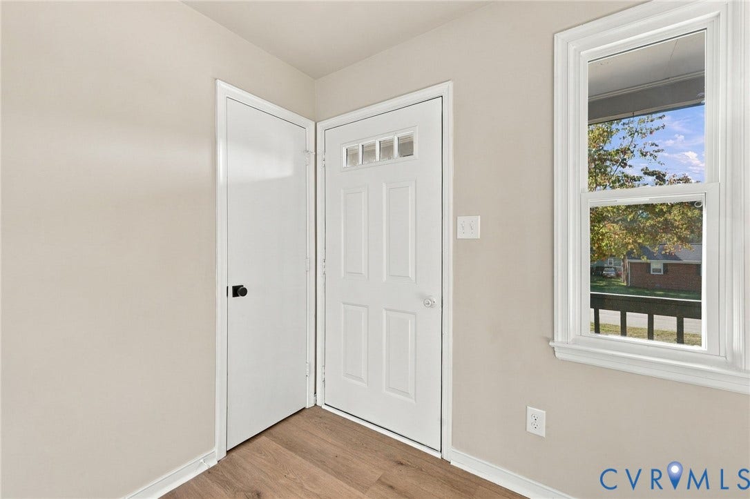 5113 Olympic Lane, North Dinwiddie, VA 23803 Entryway with wood-finish flooring, white paneled door, and a multi-pane window