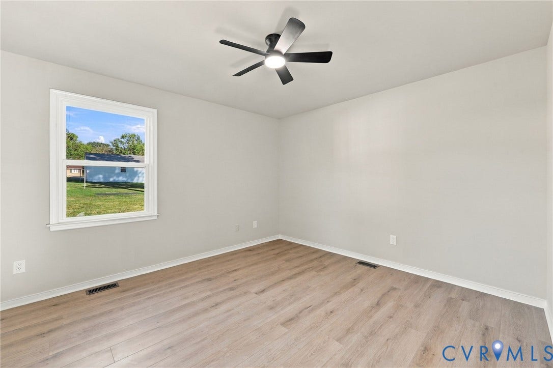5113 Olympic Lane, North Dinwiddie, VA 23803 Light-toned walls, wood-finish flooring, a window providing natural illumination, and a ceiling fan with integrated lighting
