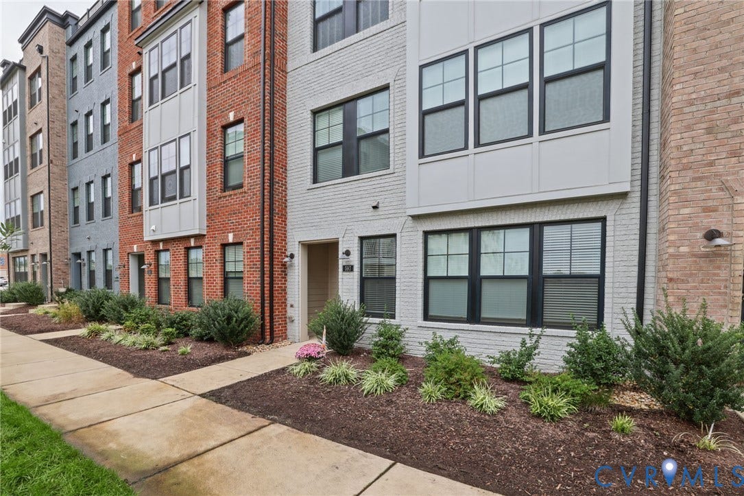 597 Weaver Brook Walk, #B, Richmond, VA 23233 Modern multi-story exterior featuring painted brick masonry, prominent bay windows, dark window frames, and exterior wall-mounted lighting