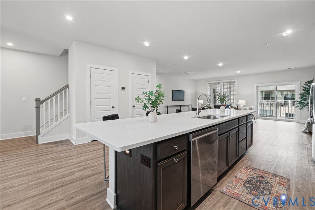 597 Weaver Brook Walk, #B, Richmond, VA 23233 Kitchen island with stone-finish countertop, stainless steel undermount sink, dark-finish cabinetry, recessed lighting, and wood-finish flooring