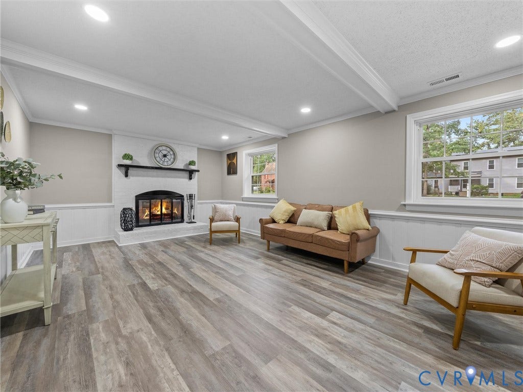 2031 Esquire Road, Midlothian, VA 23235 Recessed lighting illuminates wood-finish flooring, a white brick fireplace, and paneled wainscoting