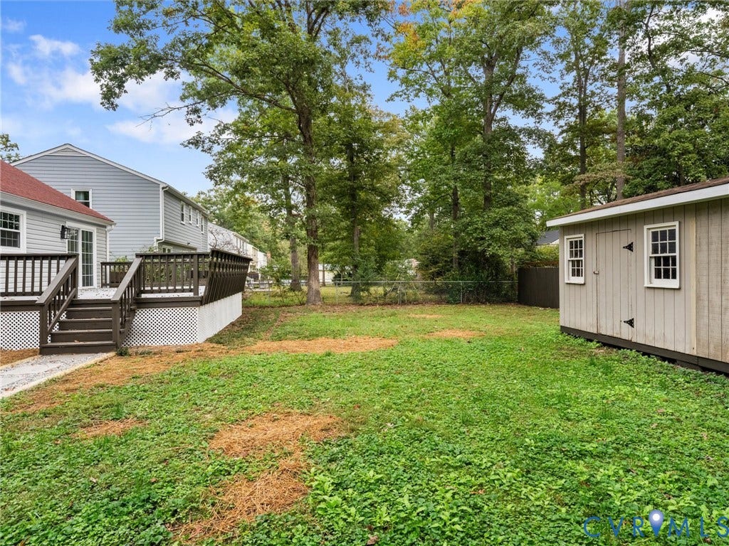 2031 Esquire Road, Midlothian, VA 23235 Expansive green space featuring a multi-level deck with dark wood railing, a shed with decorative window details, and mature trees