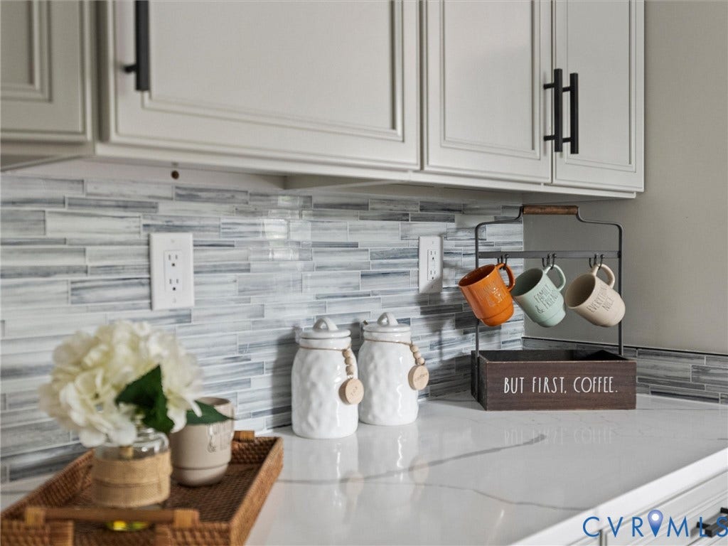 2031 Esquire Road, Midlothian, VA 23235 White paneled cabinetry with matte black hardware, horizontal tile backsplash, and light-toned countertop