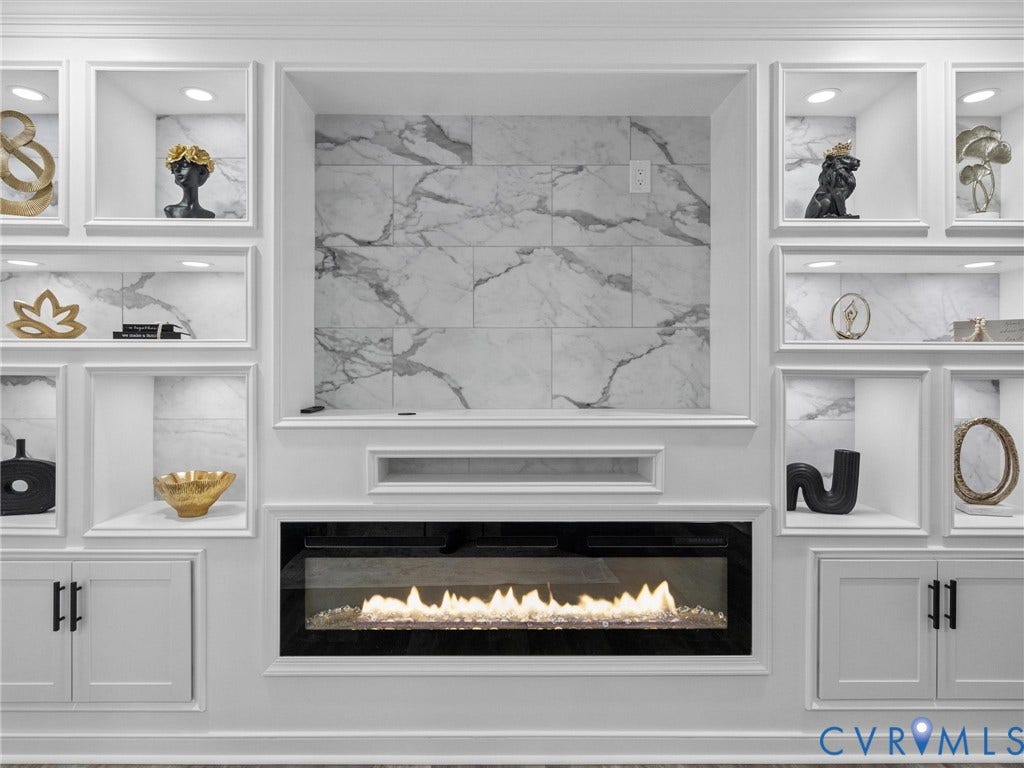 2031 Esquire Road, Midlothian, VA 23235 Built-in cabinetry with interior lighting, integrated linear electric fireplace, tile accent wall, and matte black hardware