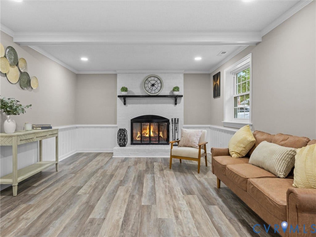 2031 Esquire Road, Midlothian, VA 23235 Recessed lighting, wood-finish flooring, white panel wainscoting, a brick fireplace with a black mantel, and a multi-pane window