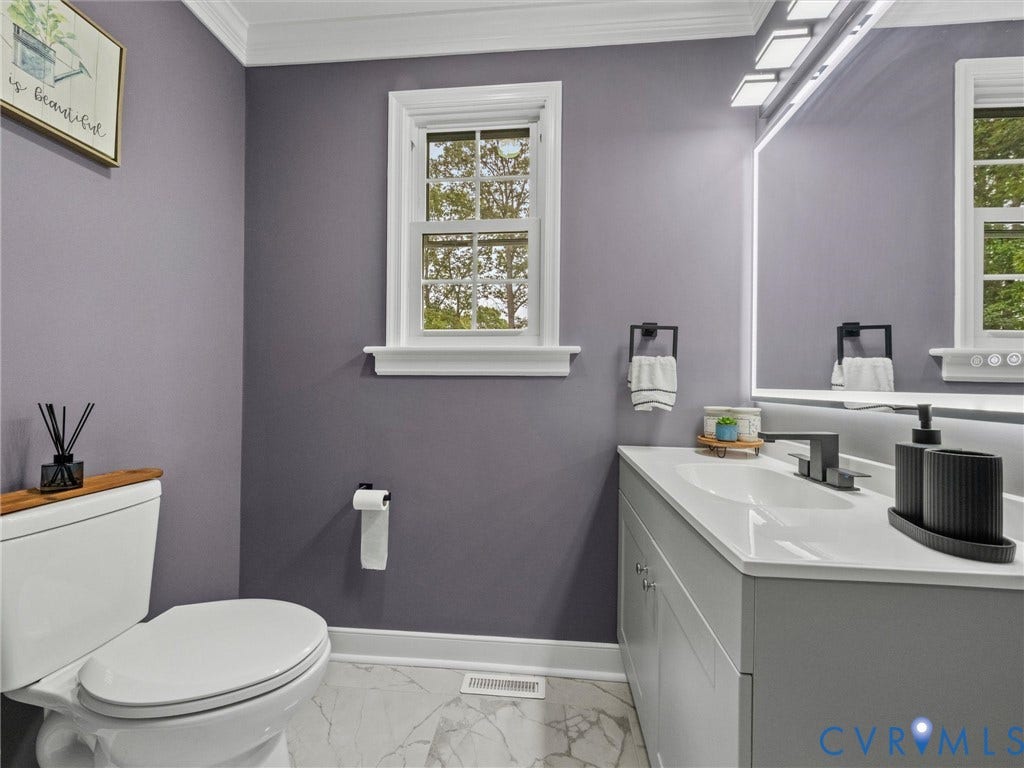 2031 Esquire Road, Midlothian, VA 23235 White crown molding, double-hung window, gray vanity with integrated sink, matte black faucet, and patterned floor tile