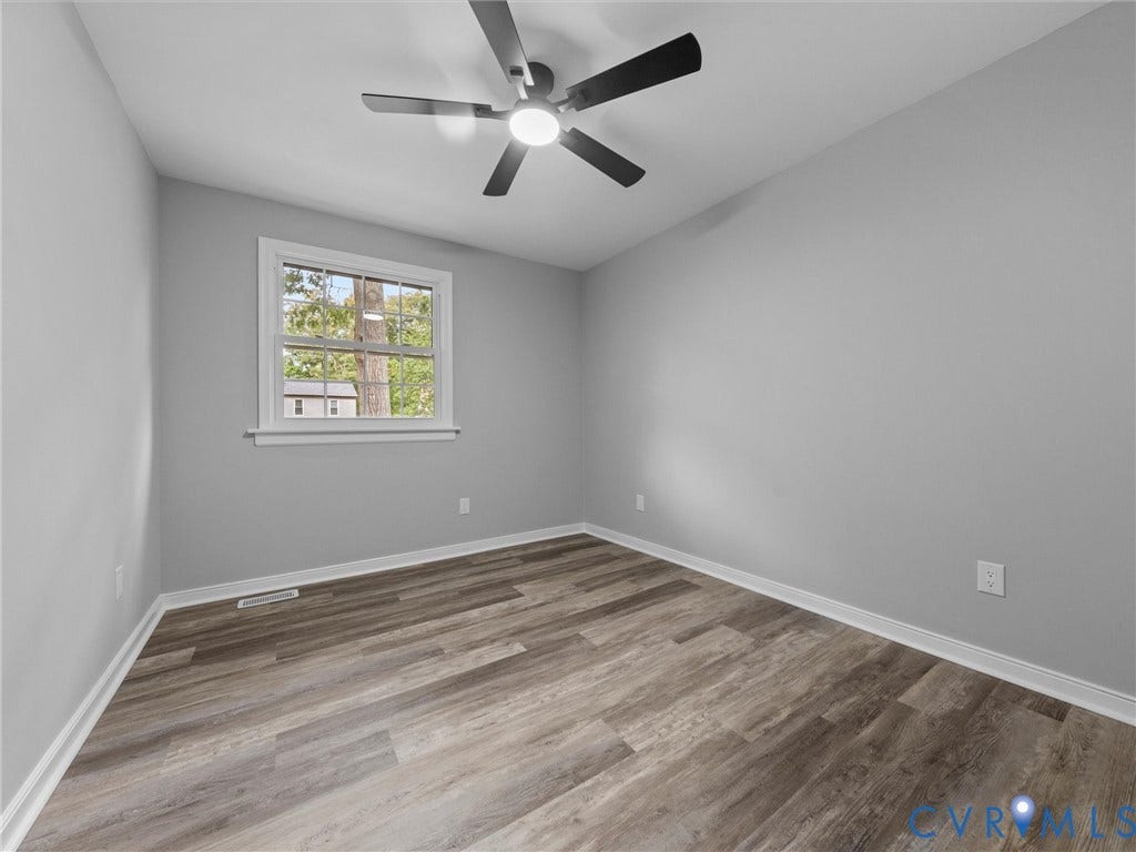 2031 Esquire Road, Midlothian, VA 23235 Wood-finish flooring, neutral gray walls, bright window with white trim, and a contemporary ceiling fan with integrated lighting