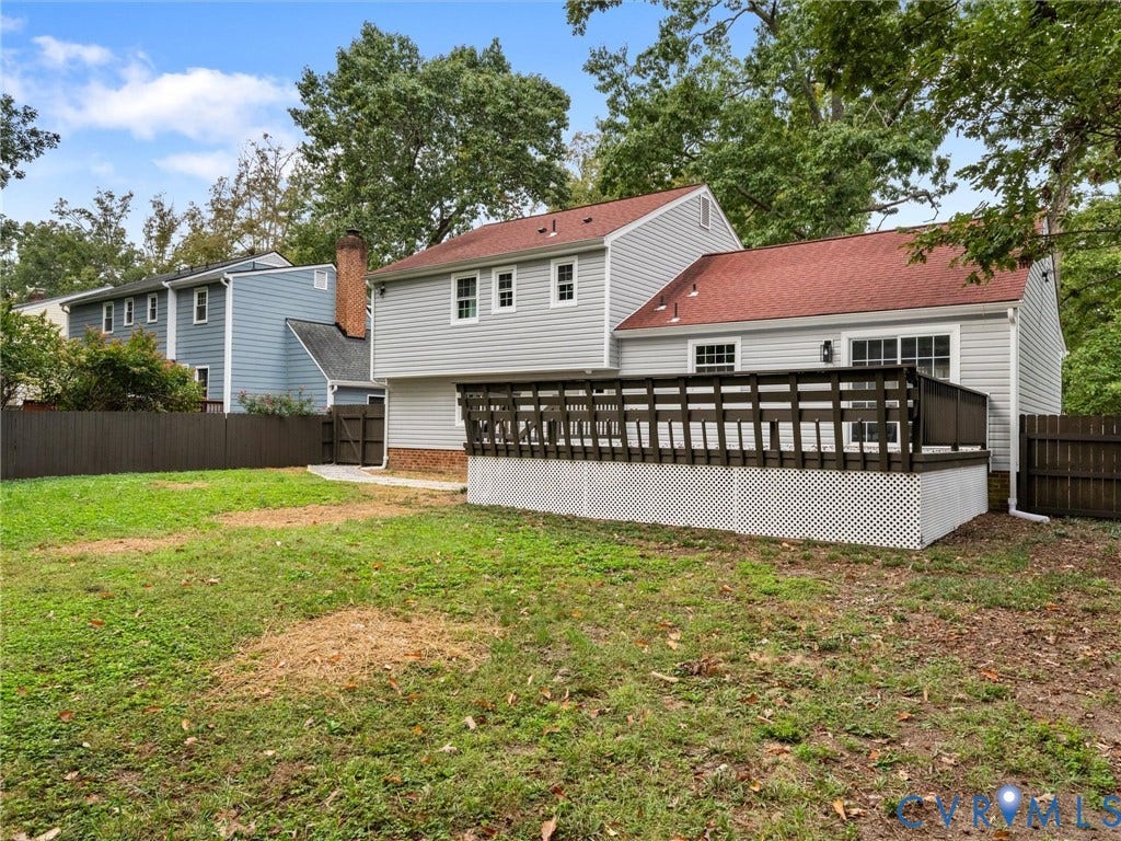 2031 Esquire Road, Midlothian, VA 23235 Rear exterior featuring gray siding, a red shingled roof, a dark wood-finish deck with lattice skirting, and a fenced yard