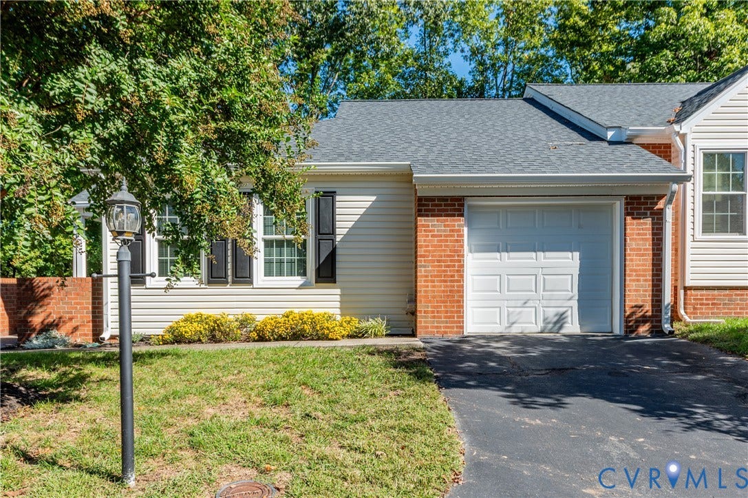 Brick and siding exterior with a shingle roof and an attached garage