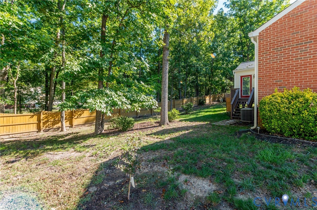 Wood privacy fence bordering a treed yard