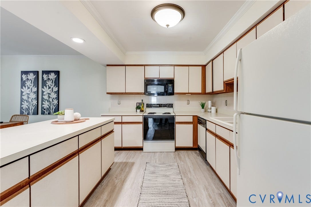 Kitchen featuring wood-finish cabinetry, white countertops, built-in microwave, integrated dishwasher, and wood-finish flooring