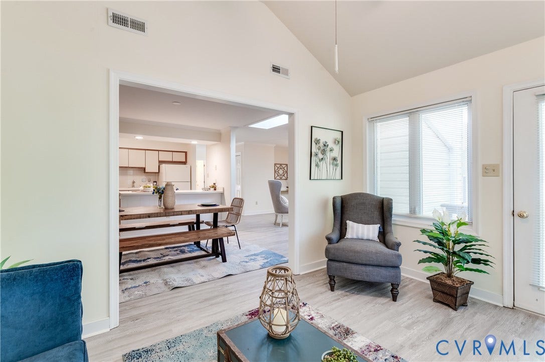 Vaulted ceiling, wood-finish flooring, white trim, recessed lighting, and a white interior door