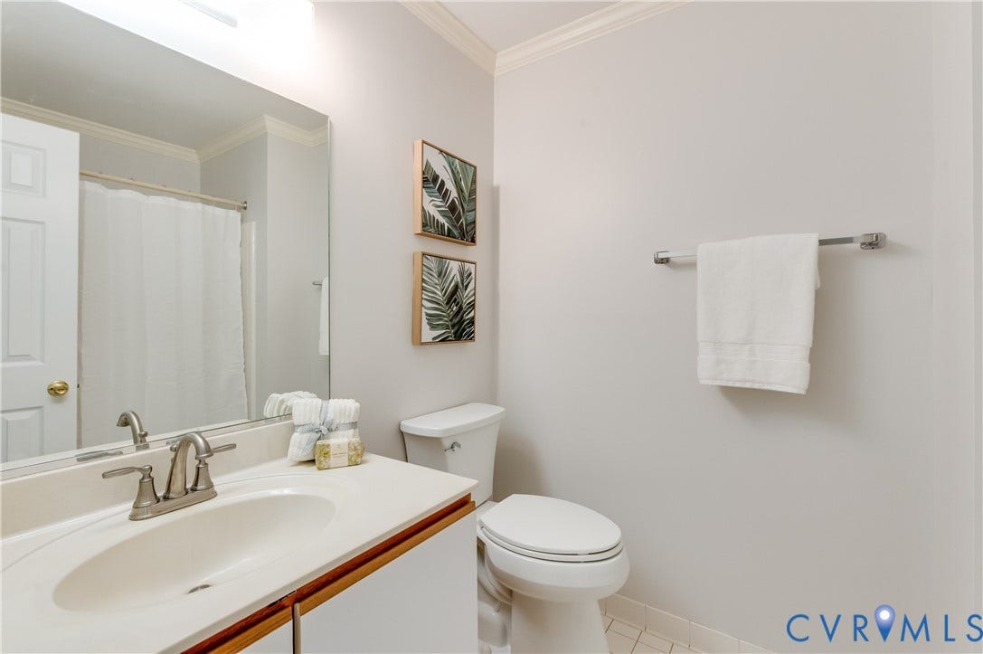 White vanity with an integrated sink, brushed nickel faucet, and a large wall mirror