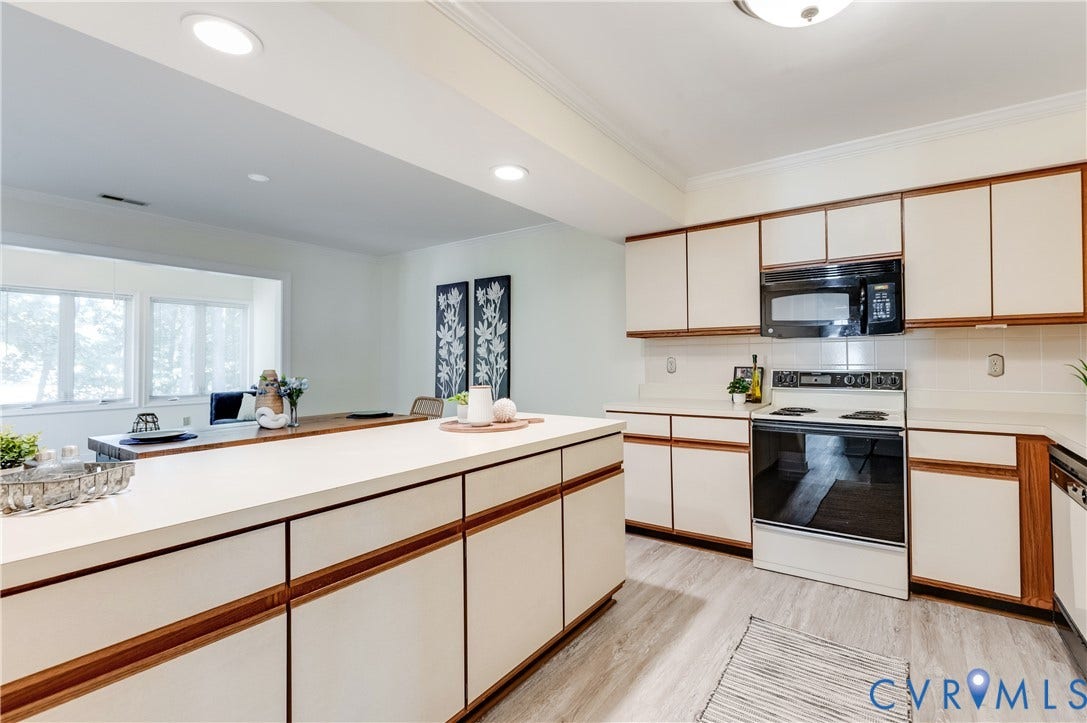 Kitchen featuring a built-in microwave, white electric range, wood-finish flooring, white cabinetry with wood trim, and white countertops