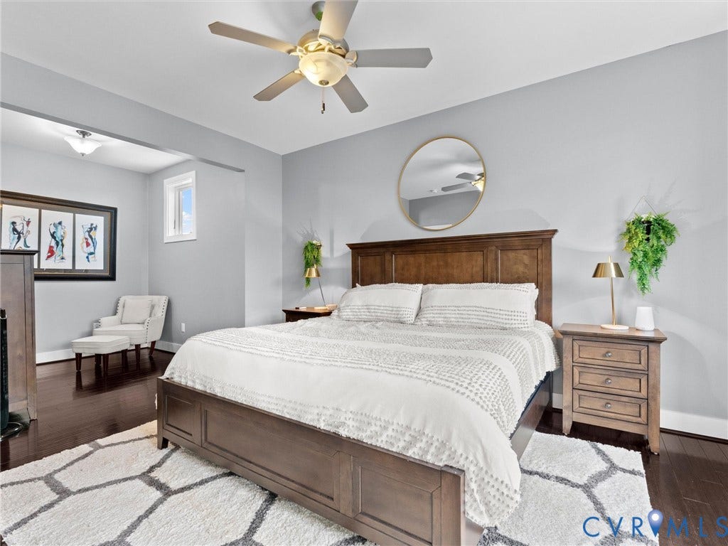 Dark wood-finish flooring throughout, ceiling fan with integrated lighting, and recessed overhead lighting
